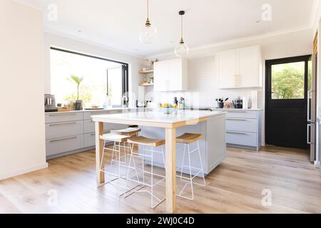 A modern kitchen interior bathes in natural light, with copy space Stock Photo