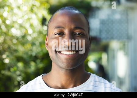 Young African American man smiles brightly outdoors Stock Photo