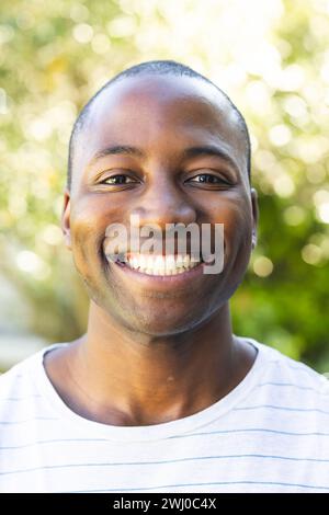 Young African American man smiles brightly outdoors Stock Photo