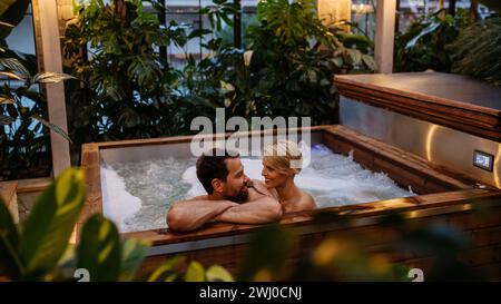 Beautiful mature couple relaxing in hot tub, enjoying romantic wellness weekend in spa. Concept of Valentine's Day. Stock Photo