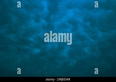 Dramatic mammatus clouds in moody view. Cloudscape background. Stock Photo