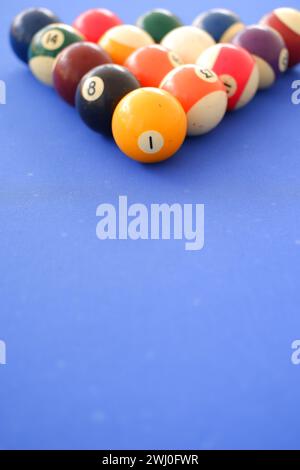 Billard balls and billard cue close up on blue billard table outdoors in a sunny summer day. Balls prepared in triangle shape Stock Photo