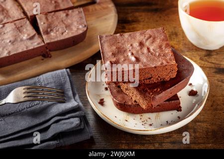 Chocolate brownie with tea, simple coffee cake, on a dark rustic table Stock Photo