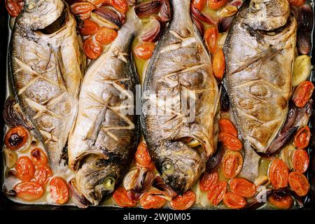 Whole sea bream baked in sauce with vegetables. Top view Stock Photo