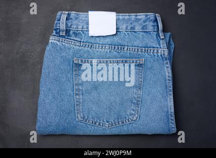 Folded blue jeans on a black background, top view Stock Photo