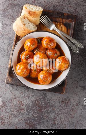 Chicken meatballs in honey glaze and spicy sauce close-up in a bowl on the table. Vertical top view from above Stock Photo