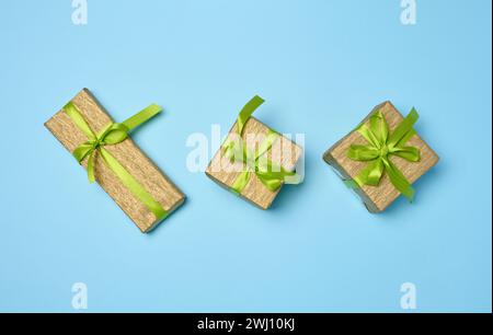 Boxes packed in paper and tied with ribbon on a blue background, gifts Stock Photo