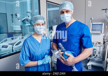 Portrait of medical technicians holding medical equipment standing in ICU while working day. Intensive care workers Stock Photo