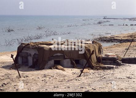 10th March 1991. An abandoned Iraqi bunker overlooking barbed-wire defences on the seafront in Kuwait City. Stock Photo