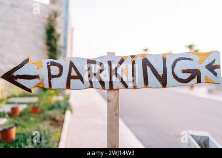 Wooden pointer with an arrow. Caption: Parking Stock Photo