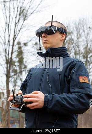 LVIV, UKRAINE - Feb. 11, 2024: A young man is seen wearing virtual reality goggles and a remote control during FPV drone flight training Stock Photo