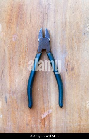 Pliers on a wooden background in a top view Stock Photo