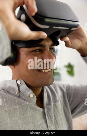 Happy biracial man using vr headset at home Stock Photo