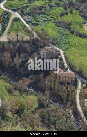 aerial view of old flour mills on the bank of a river surrounded by a green landscape Stock Photo