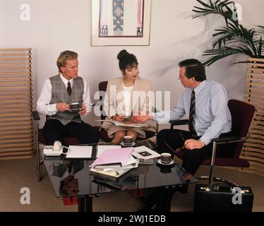 Business executives sitting around coffee table in office. Stock Photo