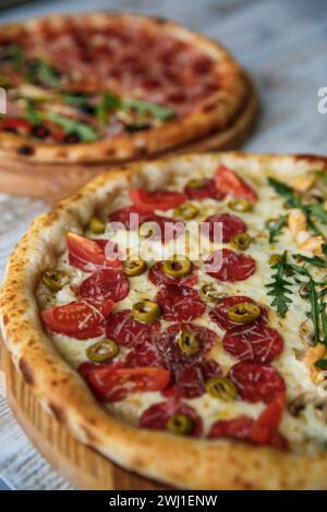 Two tasty different pizzas with variety of toppings and cheese on wooden table. top view Stock Photo