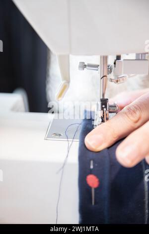 Detail of sewing work execution. Recycling clothes at home to reduce waste and avoid fast fashion. Woman sewing clothes at home. Stock Photo