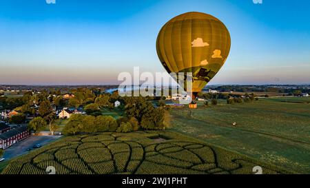 Aerial View of a Golden Hot Air Balloon, Just Launched and Floating Across a Field With a Corn Maze Stock Photo