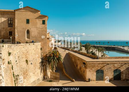 View of the medieval walls and buildings at famous Parc de La Mar as Mediterranean sea on background in Palma, Spain. Stock Photo