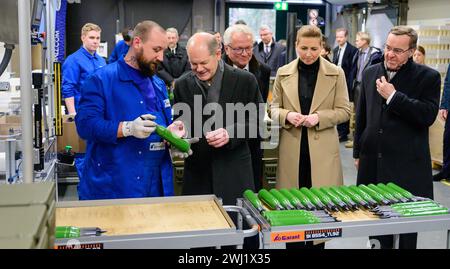 12 February 2024, Lower Saxony, Unterlüß: Federal Chancellor Olaf Scholz (SPD, 2nd from left), Armin Papperger (M), CEO of Rheinmetall, Mette Frederiksen (2nd from right), Prime Minister of Denmark, and Boris Pistorius (SPD, right), Federal Minister of Defense, inspect a production hall of the Rheinmetall armaments group. Chancellor Scholz took part in a symbolic ground-breaking ceremony to mark the start of construction of a new Rheinmetall ammunition factory. The ammunition factory will produce artillery ammunition, explosives and rocket artillery. Photo: Philipp Schulze/dpa Stock Photo