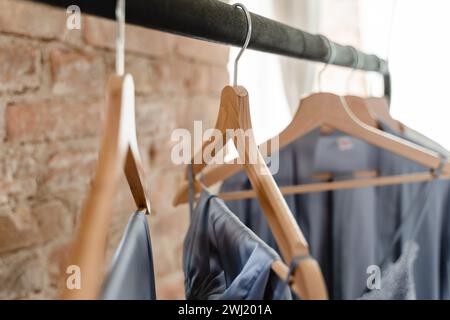 Wooden hangers with different outfits in the wardrobe Stock Photo