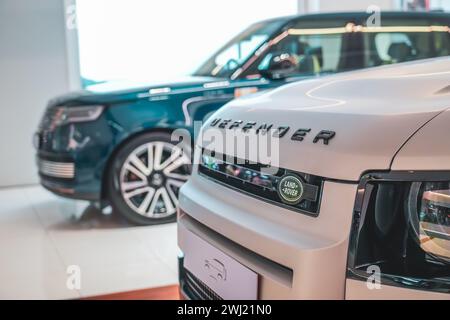 Land Rover Defender silver gray in the showroom on the shop showcase exhibition of an official dealer. Thailand, Bangkok 21 december 2023. Stock Photo