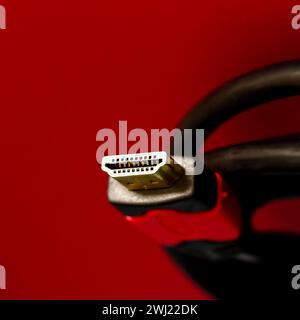 A close shot of HDMI cable isolated on a red background Stock Photo