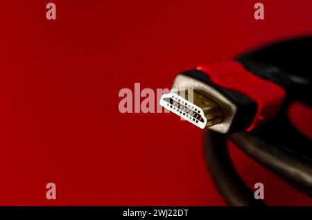A close shot of HDMI cable isolated on a red background Stock Photo