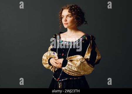 Portrait of a young aristocratic woman dressed in a medieval dress on dark background. Stock Photo