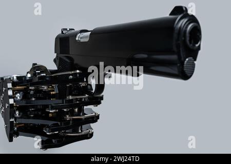 Real robot's hand with handgun. Concept of AI takeover and technological singularity Stock Photo