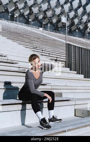 Exhausted woman athlete feeling bad during her street workout Stock Photo