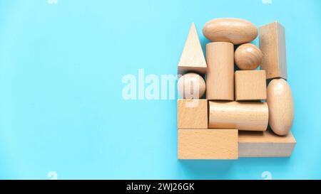 Educational toys, Cognitive skills, kid development. Montessori geometric shapes toys over a blue background. Stock Photo