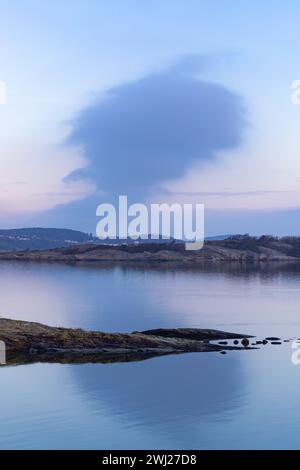 Morning sky with magenta clouds over rocky coastal landscape in Sweden Stock Photo
