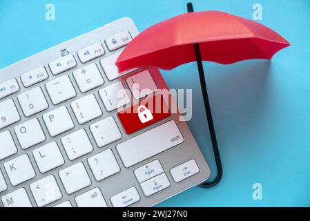 Concept of protection from cyber threat, hacker, computer virus. Red umbrella protect a red button with padlock icon. Stock Photo