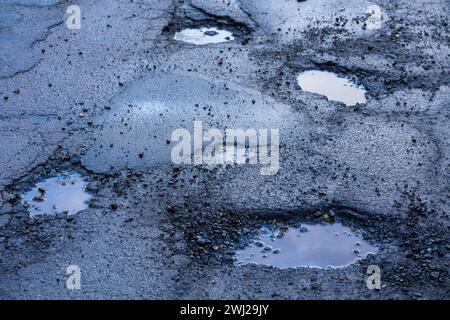 Potholes on the road after frost in winter in spring Stock Photo