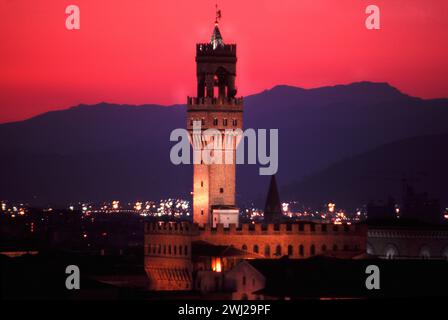 Florenz: beleuchteter Palazzo Vecchio vor blauen Bergen im Abendrot * illuminated Palazzo Vecchio backed by blue hills under red evening sky Stock Photo