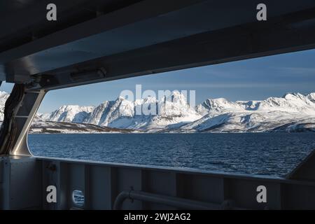 Scenic view of snowcapped mountains by sea seen through window of boat Stock Photo
