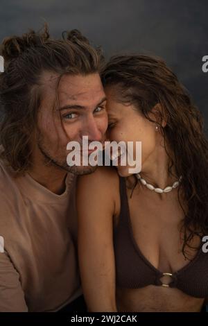 Young beautiful couple on the black sand beach, Bali Stock Photo