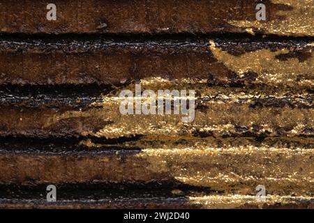 This image features a close-up shot of a textured surface with alternating golden and black stripes, showcasing intricate detail and a metallic sheen. Stock Photo