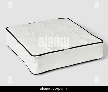 Square cushion in white patchwork leather with contrasting black trim Stock Photo
