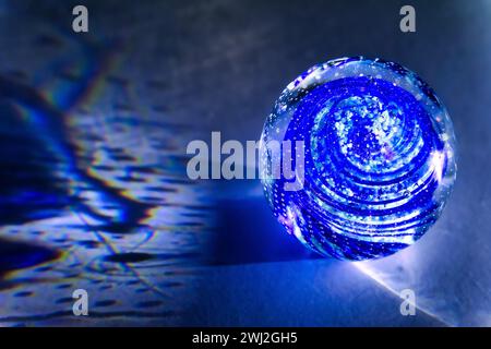 A transparent glass ball with inclusions casts real shadows on a white background Stock Photo