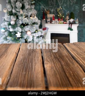 Empty wooden desk Christmas tree and fireplace in the background Stock Photo