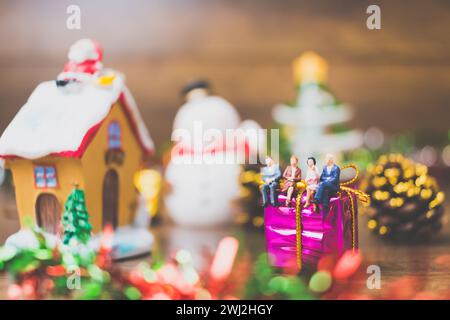 Miniature people on gift box with Christmas Day celebration background Stock Photo