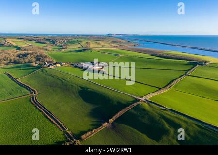 Abbotsbury, Dorset, UK.  12th February 2024.  UK Weather.  Aerial view across fields at Abbotsbury in Dorset looking along Chesil Beach and the Fleet lagoon to the Isle of Portland on the Jurassic Coast on a warm sunny afternoon.  Picture Credit: Graham Hunt/Alamy Live News Stock Photo