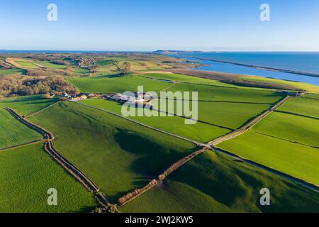 Abbotsbury, Dorset, UK.  12th February 2024.  UK Weather.  Aerial view across fields at Abbotsbury in Dorset looking along Chesil Beach and the Fleet lagoon to the Isle of Portland on the Jurassic Coast on a warm sunny afternoon.  Picture Credit: Graham Hunt/Alamy Live News Stock Photo