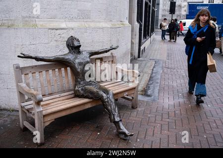 Sculpture of Beatles singer John Lennon with arms wide on a bench on Carnaby Street in a work entitled Imagine by Lawrence Holofcener on 9th February 2024 in London, United Kingdom. Stock Photo