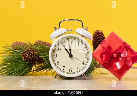 Alarm clock and stack of red gift boxes on yellow background Stock Photo