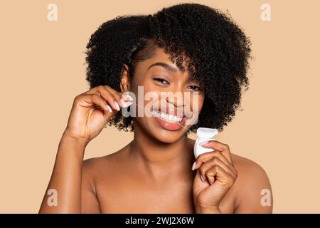 Happy african american woman flossing her teeth with bright smile Stock Photo