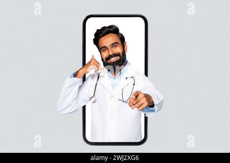 Indian male doctor in phone frame making call sign Stock Photo