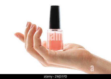 Female hand with beautiful french manicure holding bottle of pink nail polish against white background Stock Photo